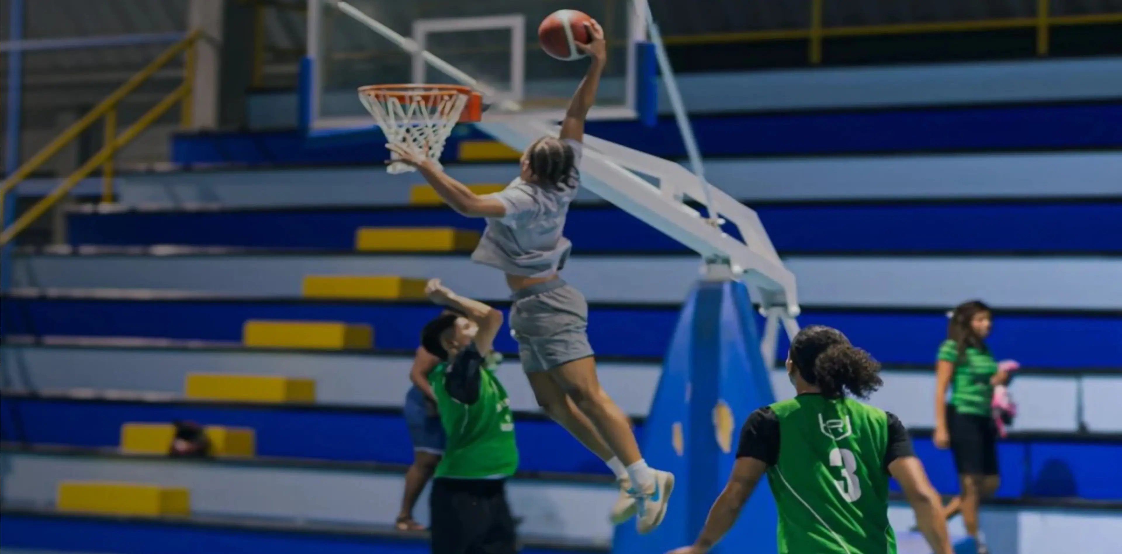 A basketball player jumps for a slam dunk during a game.