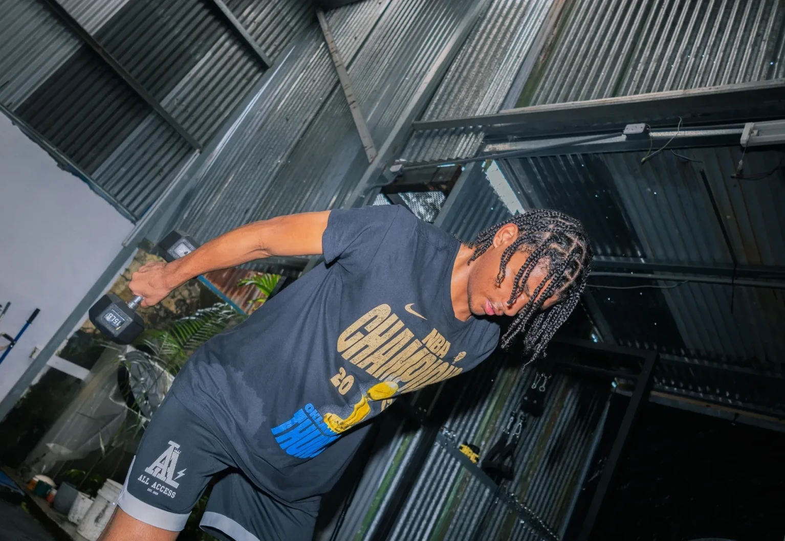 A person dancing energetically in a dark, industrial setting.